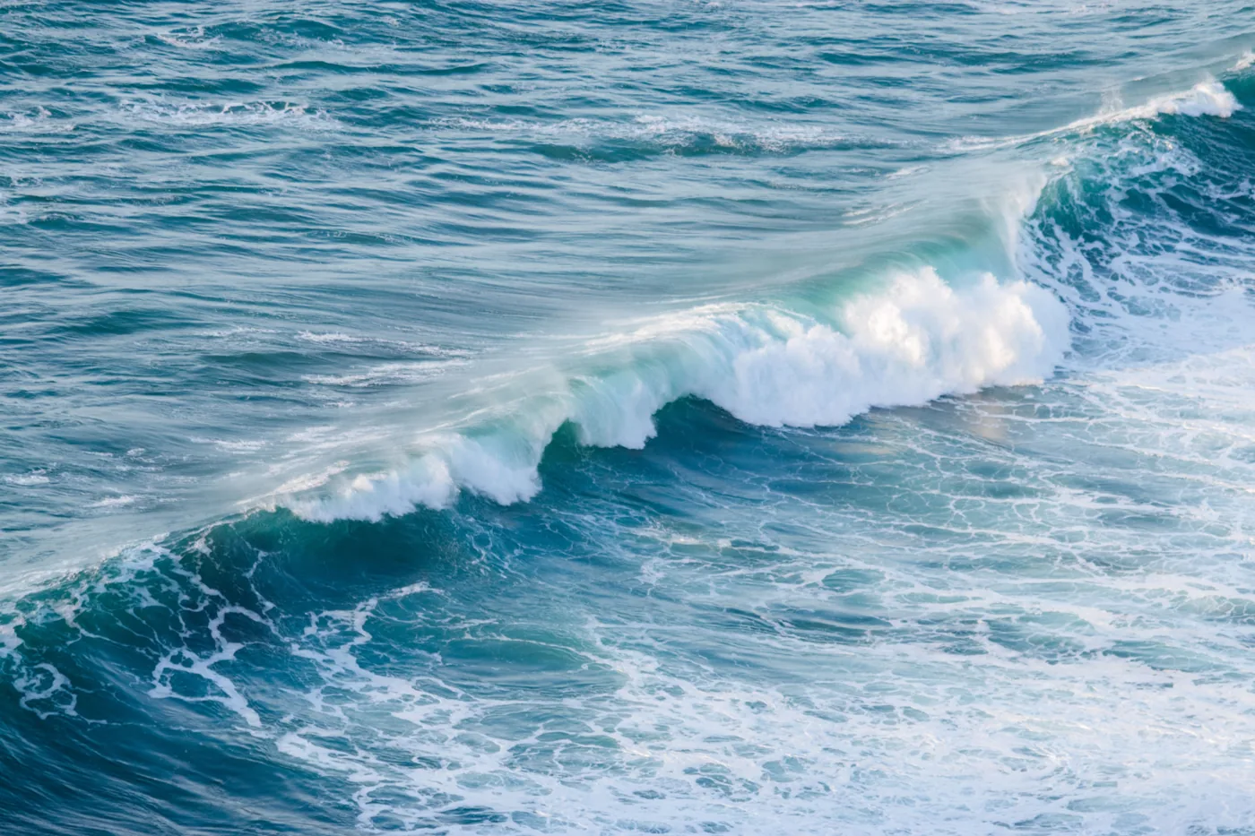 Close-up of an ocean wave cresting into white foam